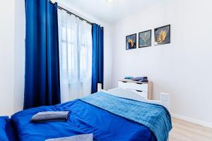 a bedroom with a blue bed and a window at Apartament Pirat in Ostróda