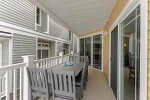 a porch with a table and chairs on a house at 8609 Landis Ave, Condo 201 in Sea Isle City