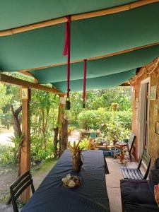 a table on a porch with a green umbrella at Pousada Oliveira Ramos in Lumiar +55 photos