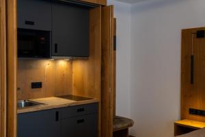 a small kitchen with a sink and a microwave at Zenger Hotel in Offenberg