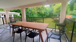 a table and chairs on a balcony with a large window at Quimelco casa de campo in La Granja