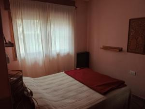 a small bedroom with a bed and a window at Quimelco casa de campo in La Granja