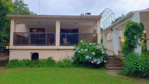 a house with a large balcony with purple flowers at Quimelco casa de campo in La Granja