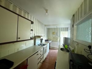 a kitchen with a sink and a stove top oven at Tranquil Hideaway with Hot Tub and Pool Table in Cardiff