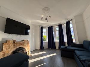 a living room with a couch and a fireplace at Tranquil Hideaway with Hot Tub and Pool Table in Cardiff