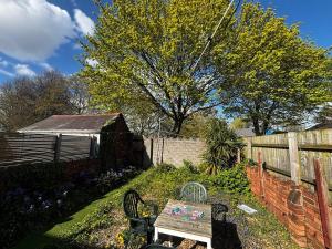 a garden with a wooden bench and a fence at Tranquil Hideaway with Hot Tub and Pool Table in Cardiff