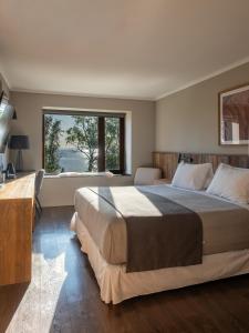 a bedroom with a large bed and a large window at Cascadas Hotel in Puerto Octay +30 photos