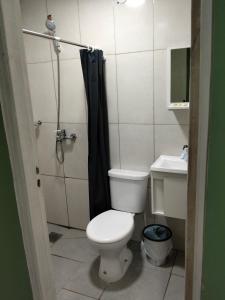 a small bathroom with a toilet and a shower at BM Apart-Alojamiento in Ciudad del Este
