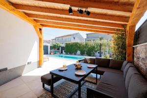 a patio with a couch and a table and a pool at HoUsE MILETIC in Solin