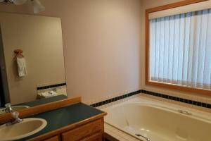 a bathroom with a tub and a sink and a mirror at 4 Approach Lane in Sunriver