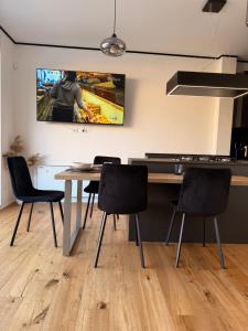a kitchen with a table and chairs and a tv on the wall at Cedrino suite apartment in Cagliari