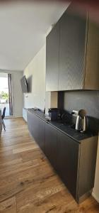 a kitchen with black cabinets and a wooden floor at Cedrino suite apartment in Cagliari