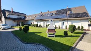a house with solar panels on the lawn at Szigetköz Győrzámoly Apartman in Győrzámoly