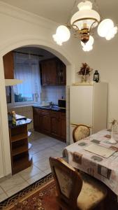 a kitchen with a table and a white refrigerator at Szigetköz Győrzámoly Apartman in Győrzámoly