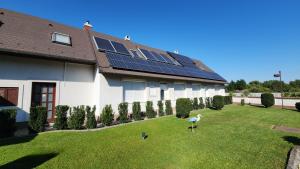 a house with solar panels on the lawn at Szigetköz Győrzámoly Apartman in Győrzámoly +3 photos