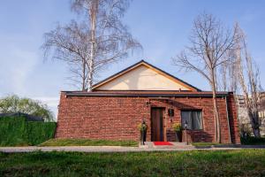a small red brick house with a door at Zoe Hotel in Prishtinë