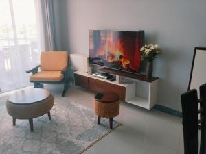 a living room with a flat screen tv and a chair at Sabaki's Homely One bedroom Apartment - Near JKIA, Airport in Marimbeti
