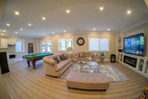 a living room with couches and a pool table at Beach House First Floor in Pickering