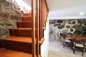 a wooden staircase in a room with a table at Casa da Madrinha - Paredes de Coura in Paredes de Coura