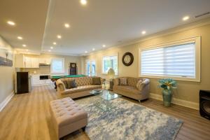 a living room with two couches and a pool table at Beach House First Floor in Pickering