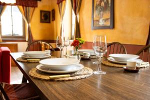a wooden table with plates and wine glasses on it at Apartments Belopeški Dvori in Kranjska Gora