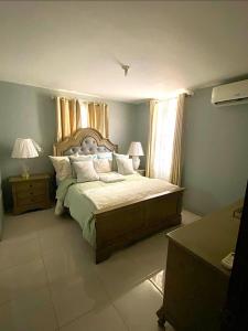 a bedroom with a large bed and a window at Caribbean Staycation in Portmore