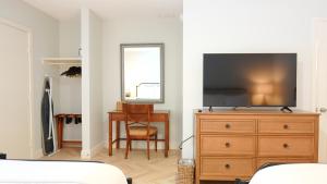 a bedroom with a dresser with a television on it at The Palm Rose in West Palm Beach +20 photos
