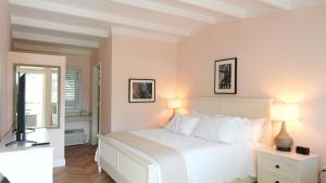 a white bedroom with a white bed and two lamps at The Palm Rose in West Palm Beach