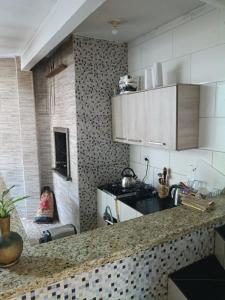 a kitchen with white cabinets and a counter top at Casa 70 Hostel 350m da praia Balneario Flamingo in Matinhos
