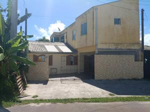 a building with a gate in front of it at Casa 70 Hostel 350m da praia Balneario Flamingo in Matinhos