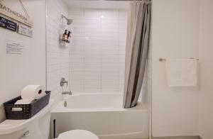 a bathroom with a white tub and a toilet at Modern & Stylish Condo Downtown KW in Kitchener +32 photos
