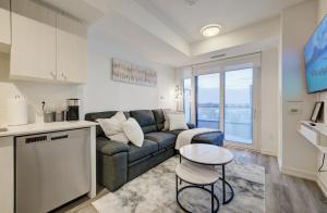 a kitchen and a living room with a couch and a table at Modern & Stylish Condo Downtown KW in Kitchener
