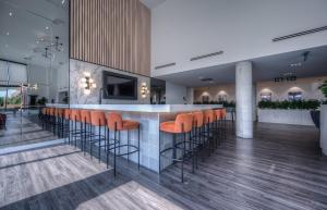 a lobby with a bar with orange bar stools at Modern & Stylish Condo Downtown KW in Kitchener