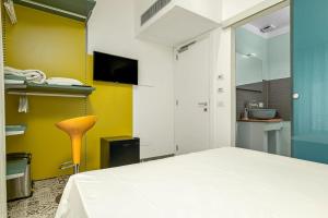 a bedroom with a white bed and a yellow wall at Gaias Rooms in Olbia