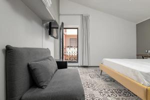 a bedroom with a bed and a couch at Gaias Rooms in Olbia