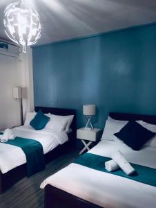 two beds in a room with blue walls at Virmuda Villa Rental in Po-oc