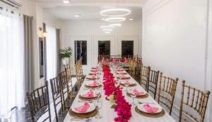 a long table in a room with pink flowers at Virmuda Villa Rental in Po-oc
