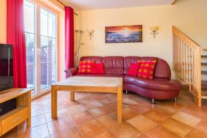 a living room with a leather couch and a tv at Ferienhaus Mandy in Wohlenberg