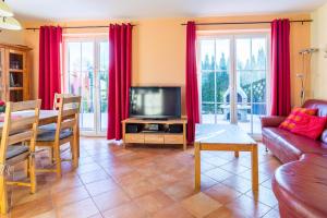 a living room with a couch and a television at Ferienhaus Mandy in Wohlenberg +25 photos