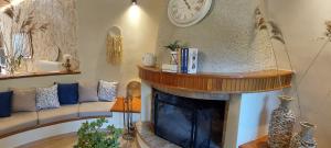 a living room with a fireplace with a clock on the wall at Gravanis Resort in Sikáminon