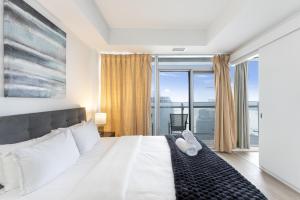 a bedroom with a large bed with a large window at The York Suites in Toronto