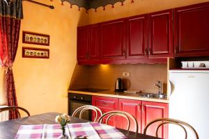a kitchen with red cabinets and a table and chairs at Apartments Belopeški Dvori in Kranjska Gora
