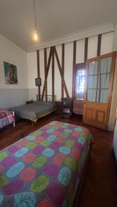 a bedroom with a large bed and a door at Casa Atahualpa in Valparaíso