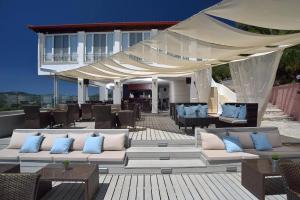 a patio with couches and tables and a tent at Marilena Sea View Hotel in Pyrgi