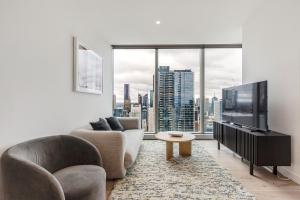 a living room with two chairs and a large window at Spencer on Rock in Melbourne