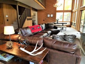 a living room with a leather couch and a table at 4 Spyglass Lane in Sunriver