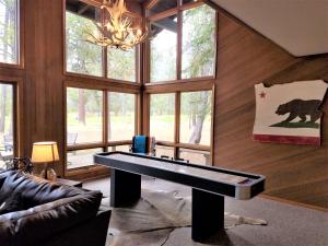 a living room with a ping pong table in front of windows at 4 Spyglass Lane in Sunriver