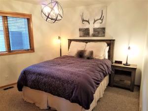 a bedroom with a bed and a chandelier at 4 Spyglass Lane in Sunriver +21 photos