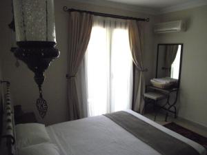 a bedroom with a bed and a large window at Dardanos Hotel in Patara
