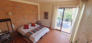 a bedroom with a bed and a brick wall at Casa Catonalco in Xalmolonco